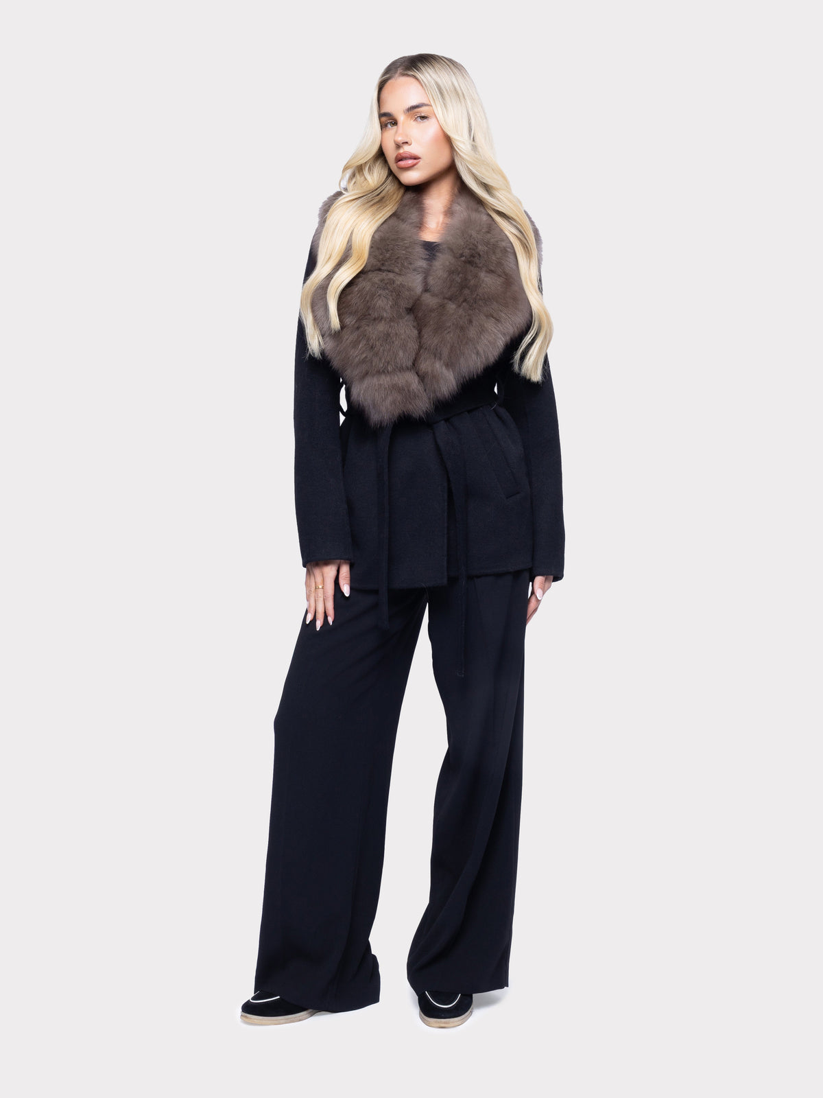Navy tailored coat with fur collar on a pale studio backdroplb2